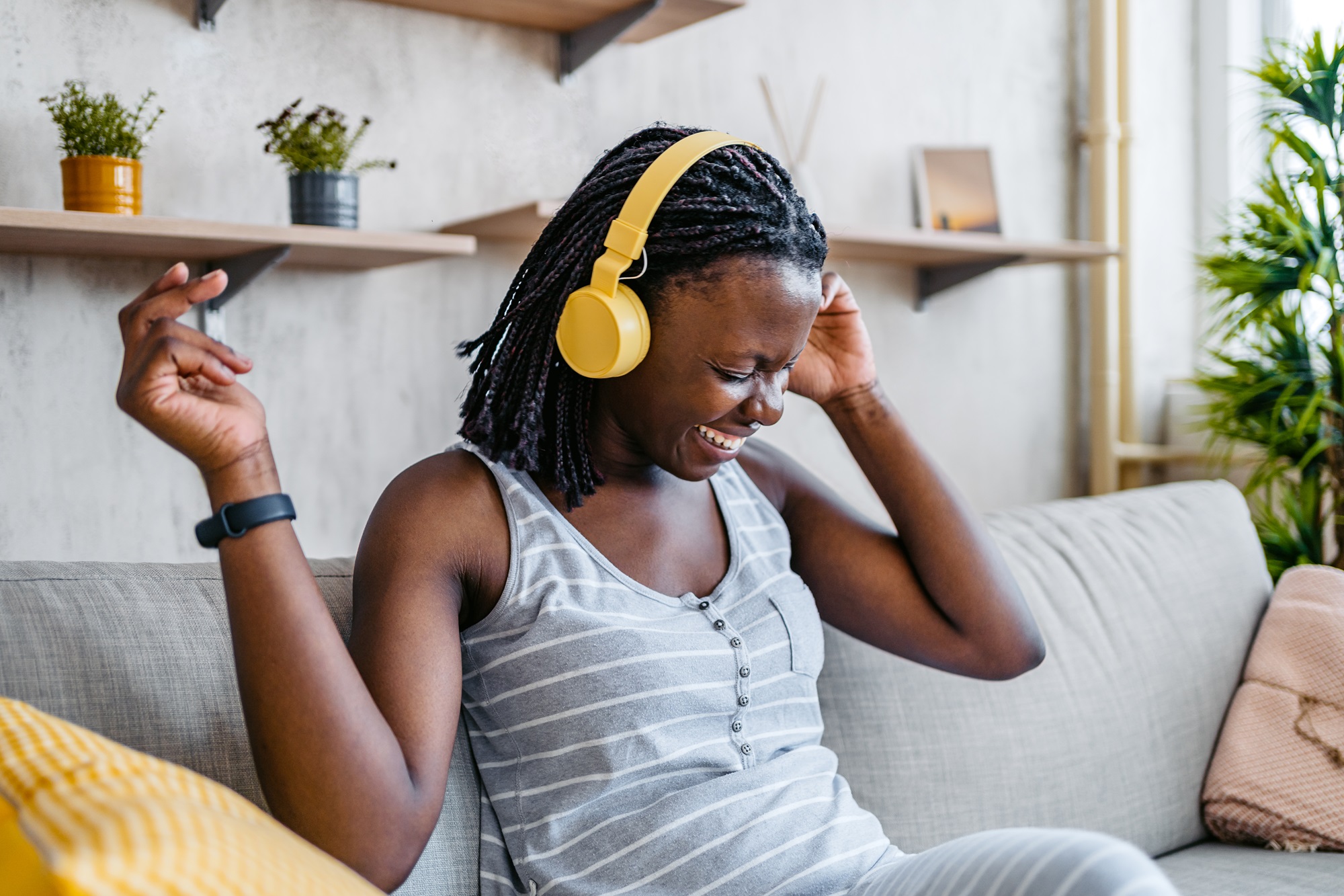 En kvinna sitter i soffan och lyssnar på något upppiggande