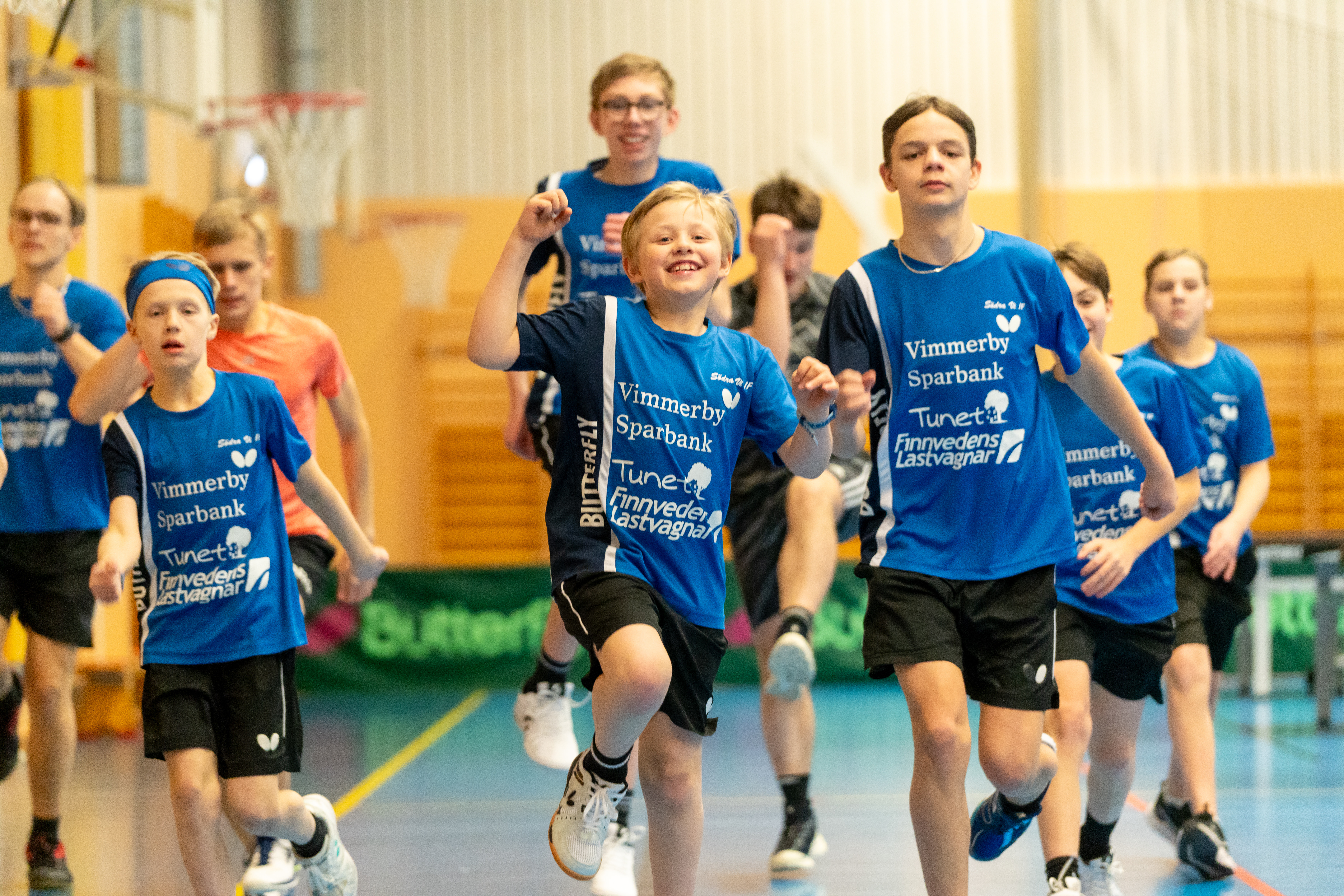 Ett lag av pojkar springer i en gympasal